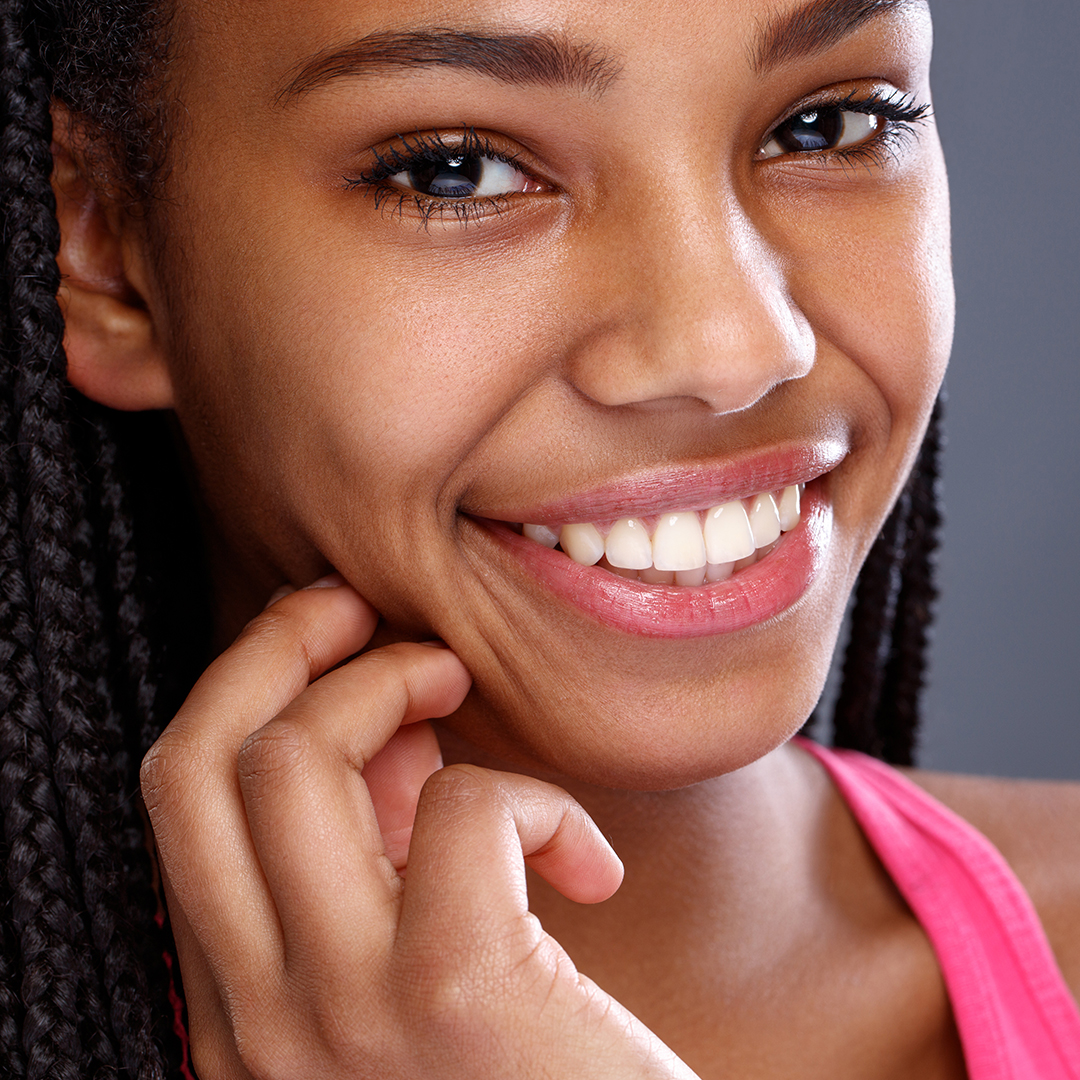 text-img3 A woman with braids smiles brightly at the camera.